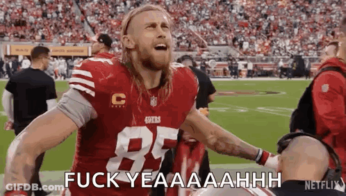 A Football Player In A Red Jersey Is Standing On A Field With His Arms Outstretched . GIF