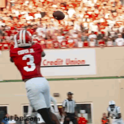 A Football Player In A Red Jersey With The Number 3 Catching A Ball GIF