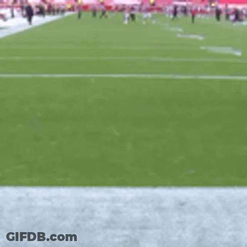A Football Player In A Red Uniform Is Running On The Field GIF