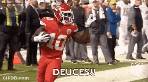 A Football Player In A Red Uniform Is Running With The Ball On The Field . GIF