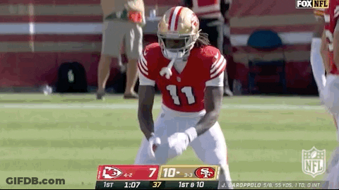 A Football Player In A Red Uniform Is Standing On The Field . GIF