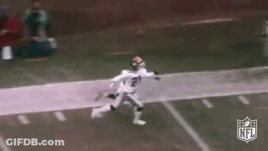 A Football Player In A White Uniform Is Running Down The Field . GIF