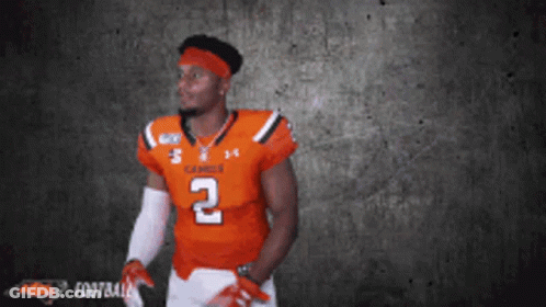 A Football Player In An Orange Jersey With The Number 2 On It GIF