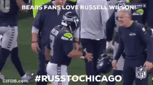 A Football Player Is Being Helped Off The Field By A Group Of Men . GIF