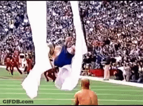A Football Player Is Flying Through The Air While A Referee Watches GIF