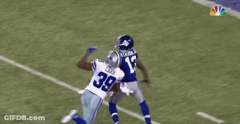 A Football Player Is Flying Through The Air While Catching A Ball . GIF