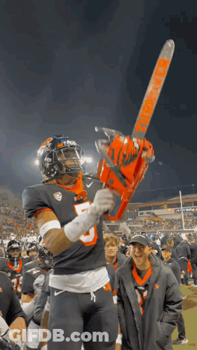 A Football Player Is Holding A Chainsaw That Says Thunder On It GIF