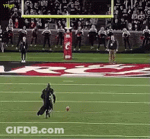 A Football Player Is Kicking A Ball On A Field With A Sign That Says ' Gatorade ' In The Background GIF