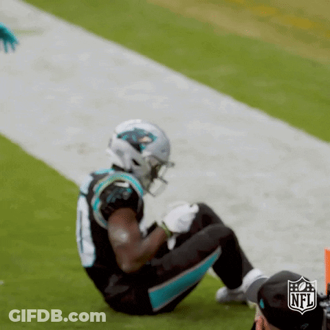 A Football Player Is Kneeling On The Field During A Game GIF