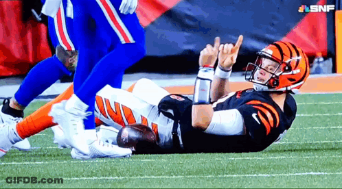 A Football Player Is Laying On The Field And Giving A Thumbs Up Sign GIF