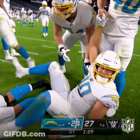 A Football Player Is Laying On The Ground During A Game Between The La Chargers And The Raiders .. GIF