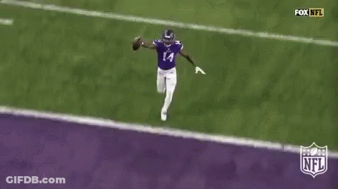 A Football Player Is Running Across A Purple Field With A Ball . GIF