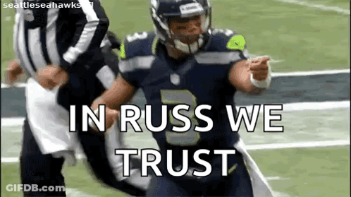 A Football Player Is Running On A Field With The Words `` In Russ We Trust '' Written On The Screen . GIF