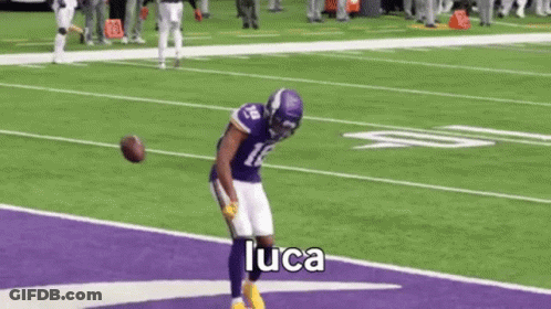 A Football Player Is Running On A Purple Field . GIF