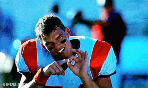 A Football Player Is Smiling And Making A Funny Face With His Hands GIF