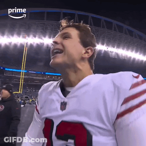 A Football Player Is Smiling In Front Of A Stadium That Says Prime On The Bottom GIF