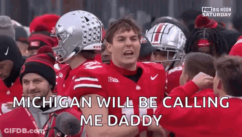 A Football Player Is Standing In Front Of A Crowd Of People And Talking To Them . GIF