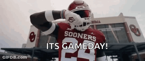 A Football Player Is Standing In Front Of A Stadium With The Words `` Its Gameday '' Written On The Screen . GIF