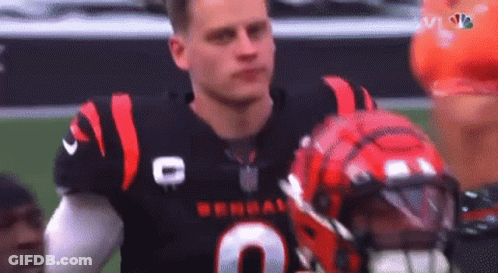 A Football Player Is Standing On A Field With His Helmet On . GIF