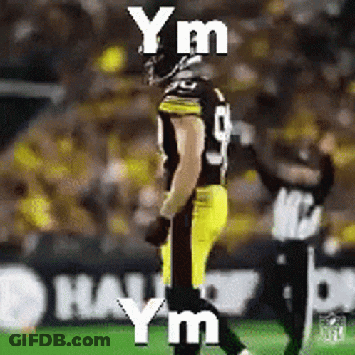 A Football Player Is Standing On A Field With The Words Y M Y M Y M Written On It GIF
