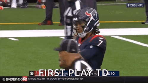 A Football Player Is Standing On The Field With A Referee . GIF