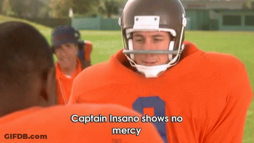 A Football Player Is Talking To Another Player On A Field . GIF