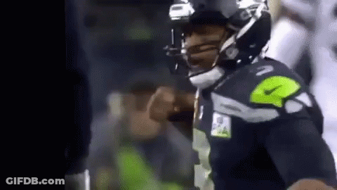 A Football Player Is Wearing A Helmet And Giving A Thumbs Up During A Game . GIF