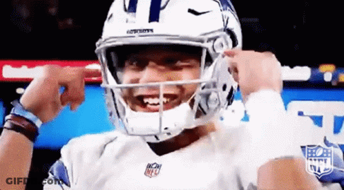 A Football Player Is Wearing A Helmet And Smiling While Holding His Hands To His Face . GIF