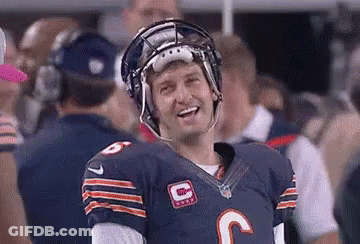 A Football Player Is Wearing A Helmet And Smiling While Standing On The Field . GIF