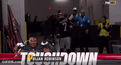 A Football Player Named Brian Robinson Is Being Congratulated GIF