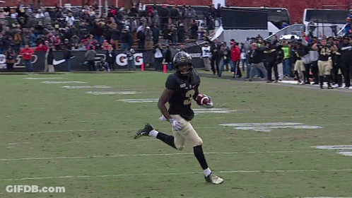 A Football Player Running On The Field With The Number 45 On His Jersey GIF