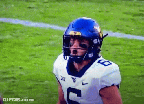 A Football Player Wearing A Blue Helmet And A White Jersey With The Number 8 On It Is Standing On A Field . GIF