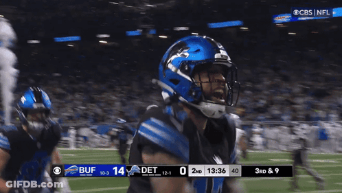 A Football Player Wearing A Blue Helmet Stands On The Field GIF