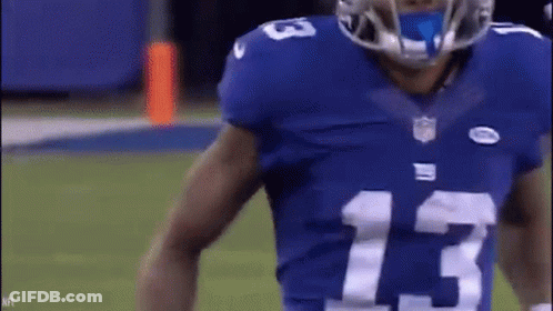A Football Player Wearing A Blue Jersey With The Number 13 On It Is Standing On A Field . GIF
