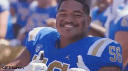 A Football Player Wearing A Blue Jersey With The Number 50 On It Is Smiling At The Camera . GIF