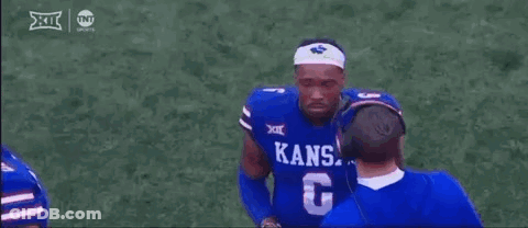 A Football Player Wearing A Blue Kansas Jersey Is Talking To A Coach . GIF