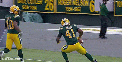 A Football Player Wearing A Green Jersey With The Number 41 On It Is Running With A Ball . GIF