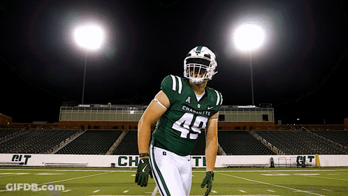 A Football Player Wearing A Green Uniform With The Number 49 On It GIF