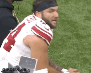 A Football Player Wearing A Headband Is Sitting On The Sidelines . GIF
