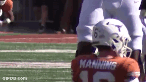 A Football Player Wearing A Helmet And A Jersey With The Name Manning On It Is Kneeling On The Field . GIF