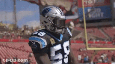 A Football Player Wearing A Helmet And A Number 50 Jersey Is Standing On A Field . GIF