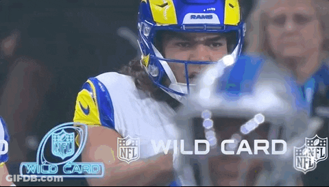 A Football Player Wearing A Helmet And A Rams Jersey Is Standing In Front Of A Crowd . GIF
