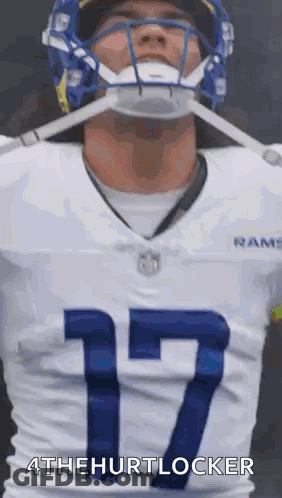 A Football Player Wearing A Helmet And A White Jersey With The Number 17 . GIF