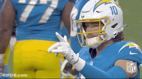 A Football Player Wearing A Helmet And Gloves Is Giving A Thumbs Up . GIF