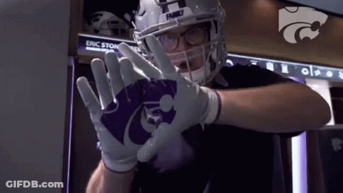 A Football Player Wearing A Helmet And Gloves With The Letter H On It . GIF