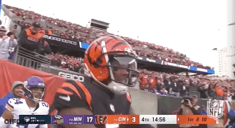A Football Player Wearing A Helmet And Goggles Is Standing On The Field . GIF