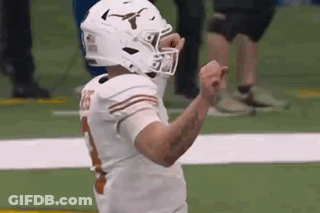 A Football Player Wearing A Helmet Is Celebrating A Touchdown On The Field . GIF