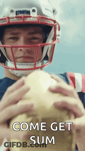 A Football Player Wearing A Helmet Is Holding A Football And Says Come Get Sum . GIF