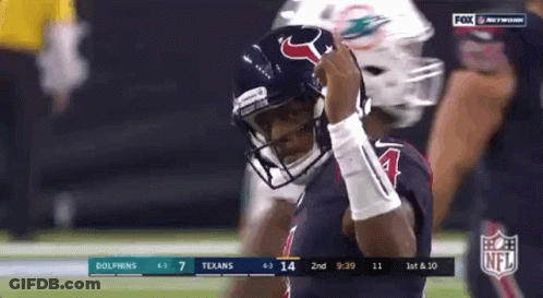 A Football Player Wearing A Helmet Is Standing On A Field . GIF