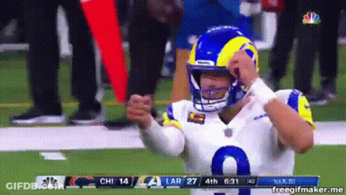 A Football Player Wearing A Helmet Is Standing On The Field . GIF